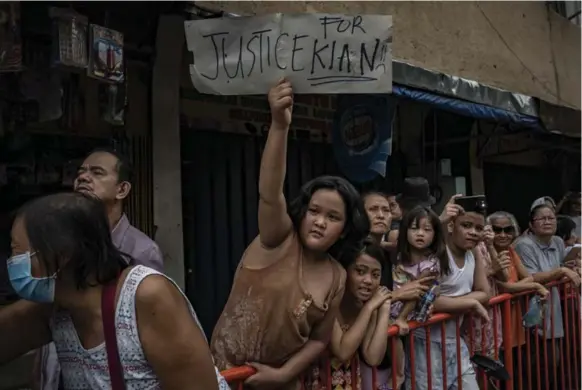  ?? JES AZNAR/GETTY IMAGES ?? Filipinos display homemade placards calling for justice for their neighbour Kian Loyd delos Santos, among 96 people killed in a police crackdown, on Saturday in Caloocan, Philippine­s.