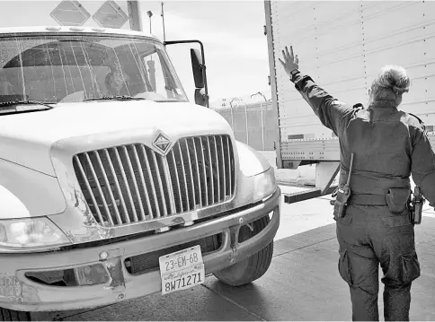  ??  ?? A US Customs and Border Protection (CBP) officer signals to a truck entering from Mexico at A border crossing in San Diego. — WP-Bloomberg photo