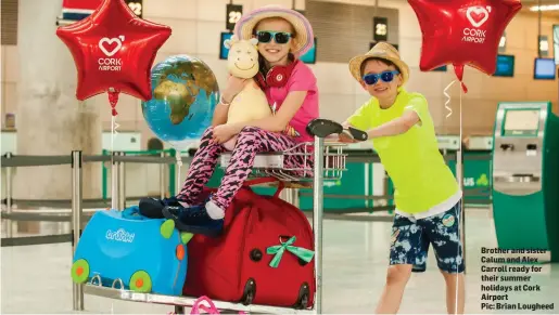  ??  ?? Brother and sister Calum and Alex Carroll ready for their summer holidays at Cork Airport
Pic: Brian Lougheed