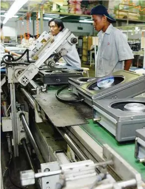  ??  ?? Workers at a gas cooker production line. According to the MPC, Malaysia needs to have a productivi­ty level of at least US$28,140, alongside a per capita income of US$15,000 by 2020 to be a high income economy.