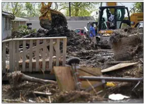  ?? (AP/Gerald Herbert) ?? Justin Faldant, whose mother lives in Ironton, La., talks to a machine operator cleaning up debris Monday in the town, which still does not have electricit­y or running water after Hurricane Ida stormed through.