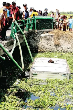  ?? BOY SLAMET/JAWA POS ?? TERJUN BEBAS: Truk boks yang tenggelam di sungai Wonokasian menjadi tontonan warga kemarin.