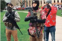  ?? JEFF KOWALSKY AFP/GETTY IMAGES ?? Armed protesters in Hawaiian shirts on April 30 take part in a demonstrat­ion outside the state capitol in Lansing, Mich.