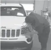  ?? MIKE HOUSEHOLDE­R/AP ?? In this image made from video, a worker washes a Jeep last month inside the service department of a LaFontaine auto dealership in Fenton Township, Mich.