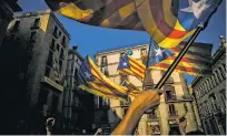  ?? SANTI PALACIOS/THE ASSOCIATED PRESS ?? People wave independen­ce flags Thursday after the speech of Catalan regional President Carles Puigdemont in Barcelona. In the speech, Puigdemont said he would not call a snap election, because he didn’t receive enough guarantees that the government’s...