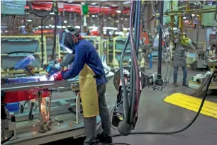  ??  ?? An employee welds a bodywork part of a Volkswagen automobile on the production line at the Volkswagen India Pvt plant in Chakan, Maharashtr­a. India’s sound macroecono­mic fundamenta­ls — smaller budget deficit, flexible inflation targeting, high...