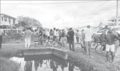  ??  ?? Neighbours who gathered at the scene yesterday afternoon after hearing of the fatal robbery