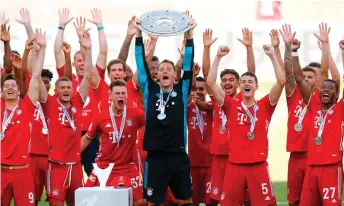  ?? — AFP photo ?? Bayern Munich’s goalkeeper Manuel Neuer lifts the trophy as Bayern Munich players celebrate after the Germa Bundesliga against match VfL Wolfsburg in Wolfsburg, northern Germany.