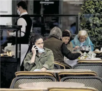  ?? JOSÉ LUIS ROCA ?? Una joven habla por teléfono en una terraza de Madrid, junto a otros clientes sin mascarilla, ayer.