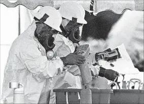  ?? LUIS M. ALVAREZ/AP ?? Workers clean at Florida’s American Media, targeted in the 2001 deadly anthrax attacks.