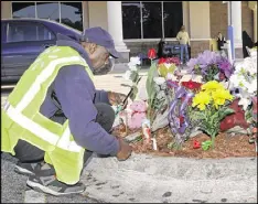  ?? JOHN RAOUX / AP ?? An employee of Walmart lights a candle at a memorial Tuesday at the parking lot where Orlando police officer Debra Clayton was shot and killed.