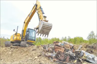  ?? SHARON MONTGOMERY-DUPE/CAPE BRETON POST ?? Ron Ivey, machine operator with MacDonald’s Trucking and Backhoe in North Sydney, works at cleaning up illegal dumping discovered on CBRM property where the water tower is located in Reserve Mines. A Reserve Mines man has been charged and police say a second individual may be charged as well.