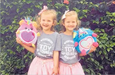  ??  ?? Toy Squad testers 5-year-old twins MacKenzie and Lucy Boderick give Zuru Rainbocorn­s the once-over for Farmers.