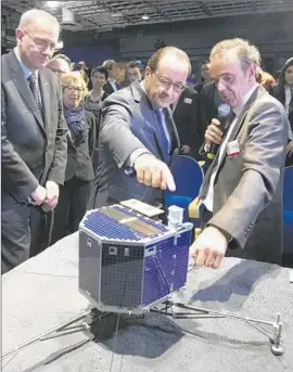  ?? Jacques Brinon Pool Photo ?? FRENCH PRESIDENT Francois Hollande, center, and astrophysi­cist Francis Rocard look at a model of the comet lander Philae in Paris in November.