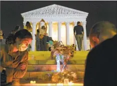  ?? Alex Brandon Associated Press ?? PEOPLE GATHER on the steps of the Supreme Court in Washington to pay tribute to Justice Ruth Bader Ginsburg, who died Friday.