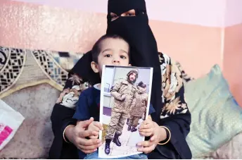  ?? ?? This photo shows a picture printout of Mohammed Asfan being held by his wife Asma Shireen and their child in Hyderabad.