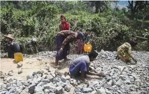  ?? — AFP ?? Rocky road: Labourers working on a road constructi­on project in Maungdaw district near the Bangladesh­i border.