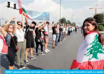  ?? —AFP ?? BEIRUT: Lebanese protesters hold hands to form a human chain along the coast from north to south as a symbol of unity during ongoing anti-government demonstrat­ions yesterday.