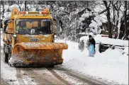  ?? JEFF J MITCHELL / GETTY IMAGES ?? A snowplow clears a road in Balloch, Scotland, on Thursday. Hundreds of drivers were trapped in their cars overnight and authoritie­s said everyone except emergency workers should stay off roads.