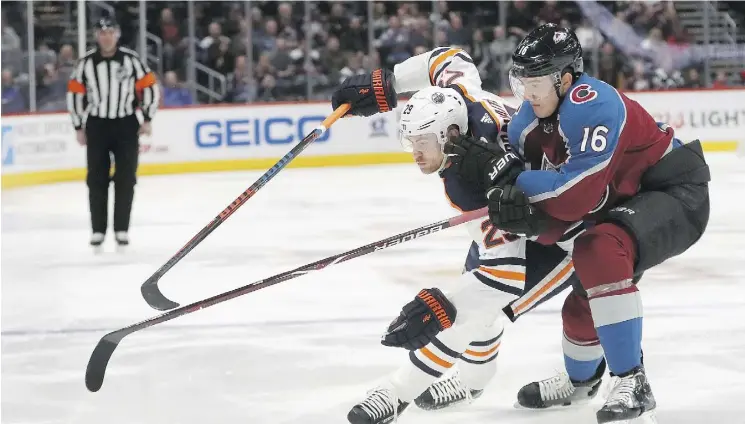  ?? MATTHEW STOCKMAN ?? Oilers forward Leon Draisaitl fights Nikita Zadorov of the Avalanche for control of the puck Tuesday night in Denver, Colo. The Oilers won 6-4.
