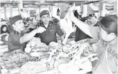 ??  ?? ROSLEE (tengah) dan Timbalan Ketua KPDNKK Sibu, Ganda Jirap (kiri) membuat pemeriksaa­n salah sebuah gerai menjual ayam segar di Pasar Sentral Sibu.