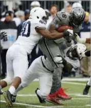  ?? JAY LAPRETE - AP ?? Ohio State quarterbac­k J.T. Barrett, top right, is sacked by Penn State defenders Jason Cabinda, left, and Manny Bowen during the first half of an NCAA college football game Saturday, in Columbus, Ohio.