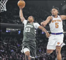  ?? Sarah Stier The Associated Press ?? Bucks guard Sterling Brown soars to the basket past Knicks guard Dennis Smith Jr. in the second half of Milwaukee’s 123-102 win Saturday at Madison Square Garden.