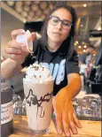  ??  ?? Gracie Garcia makes one of Grub Burger Bar’s signature spiked chocolate milkshakes.