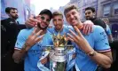  ?? ?? Kyle Walker, Ruben Días and John Stones celebrate with the Premier League trophy – the club’s fourth title in five seasons. Photograph: Matt McNulty/Manchester City/Getty Images