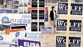  ?? Eric Gay / AP ?? Rebecca González busca un espacio para colocar un cartel electoral en una localidad de votación temprana de las primarias del 4 de marzo, en San Antonio.