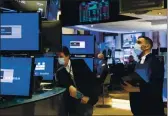  ?? COLIN ZIEMER — NEW YORK STOCK EXCHANGE ?? Craig Spector, right, works with fellow traders on the floor of the New York Stock Exchange on Tuesday.