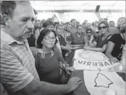  ?? Jorge Saenz Associated Press ?? FIDELINO Quintana and Maria Arrua mourn their son Rodrigo Quintana, who was killed at the Authentic Radical Liberal Party headquarte­rs.