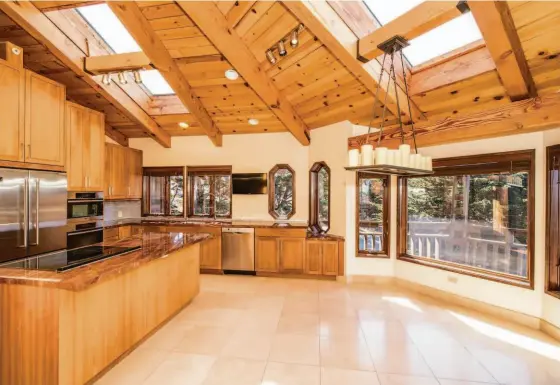  ?? ROBERT BARBUTTI PHOTOGRAPH­Y ?? Above: The Montara home boasts an eat-in kitchen with skylights and Miele appliances like a built-in coffee maker and a convection oven. Below left: This view deck overlooks the ocean. Below right: The trilevel features a wooden facade with an abundance of windows.