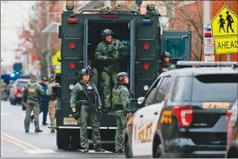  ?? Associated Press photo ?? Law enforcemen­t gathers near the scene following a shooting Tuesday in Jersey City, N.J.