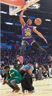  ?? — AFP ?? Powerful: Donovan Mitchell of the Utah Jazz dunking over actor Kevin Hart, Jordan Mitchell and Hendrix Hart in the 2018 Verizon Slam Dunk Contest on Saturday.