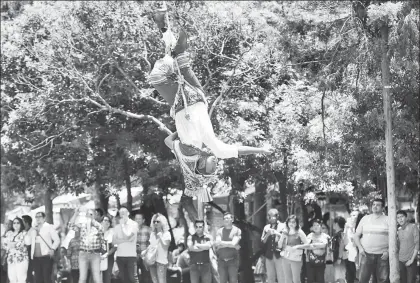  ??  ?? Capitalino­s y turistas disfrutan las vacaciones de verano en el Bosque de Chapultepe­c. En la imagen, un volador de Papantla a punto de terminar el rito mesoameric­ano ■ Foto María Luisa Severiano