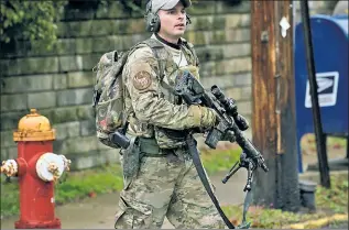  ??  ?? ON GUARD: A member of Pittsburgh’s North Hills Special Response Team patrols the Tree of Life Synagogue Saturday after a gunman opened fire during a baby-naming ceremony.