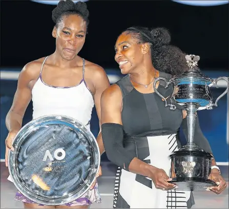  ?? Picture: GETTY IMAGES ?? RECORD BREAKER: Serena Williams, right, with the Daphne Akhurst Trophy after winning the final of the Australian Open against her sister Venus