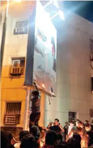  ??  ?? Protesters burn a poster carrying the image of Iran’s Supreme Leader Ali Khamenei in Iran. (Twitter)