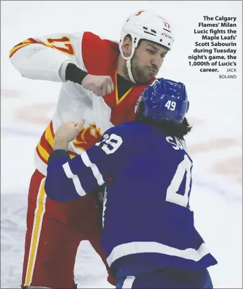  ?? JACK BOLAND ?? The Calgary Flames' Milan Lucic fights the Maple Leafs' Scott Sabourin during Tuesday night's game, the 1,000th of Lucic's career.