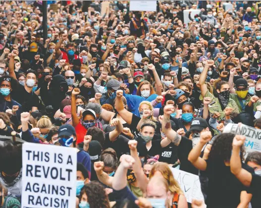  ?? JOSEPH PREZIOSO/AFP VIA GETTY IMAGES ?? Protesters in Boston raise their fists in a moment of silence during an event this week for George Floyd and other victims of police brutality.