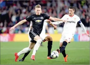  ?? CRISTINA QUICLER/AFP ?? Manchester United midfielder Scott McTominay (left) vies for the ball with Sevilla’s Sergio Escudero in their UEFA Champions League match on Wednesday night.