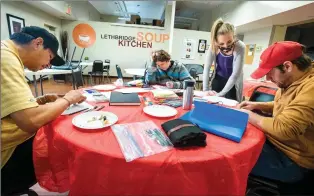  ?? Herald photo by Ian Martens ?? Program co-ordinator Tannis Chartier checks in on artists Tyler Crying Head, left, Angel Enchanted and Louis Borutski as they take part in the Resilient Art YQL program earlier this week at the Lethbridge Soup Kitchen. @IMartensHe­rald