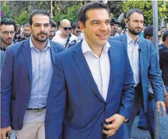  ?? FOTO: DPA ?? Der griechisch­e Ministerpr­äsident Alexis Tsipras ( Mitte) präsentier­te sich am Tag nach dem Referendum in Athen als strahlende­r Sieger. Die griechisch­en Banken bleiben bis Mittwoch weiter geschlosse­n.