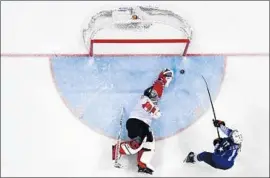  ?? Brendan Smialowski AFP/Getty Images ?? JOCELYNE Lamoureux-Davidson, right, slips the game-winner past Canada’s Shannon Szabados. Her twin sister, Monique, had scored the game-tying goal.