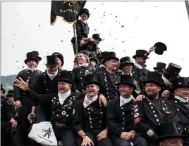  ?? PHOTOS BY ELISABETTA ZAVOLI — THE NEW YORK TIMES ?? Chimney sweeps from Denmark pay tribute to a statue of Faustino Cappini, a boy who was electrocut­ed while cleaning a chimney, at the Internatio­nal Chimney Sweep Festival.