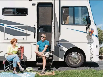  ?? BENJAMIN RASMUSSEN/THE NEW YORK TIMES ?? Tom and Mona Mesereau sit in the sun outside their Winnebago in Evergreen, Colorado. The Mesereaus have logged 18,000 miles since 2018.