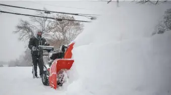  ?? NICOLaUs CzarNECkI / HEraLd sTaFF FILE ?? THAT’S NEW ENGLAND FOR YOU: Woburn resident Bhakta Shrestha cleans his driveway as the region was hit with a storm bringing more than a foot of snow on Dec. 17.