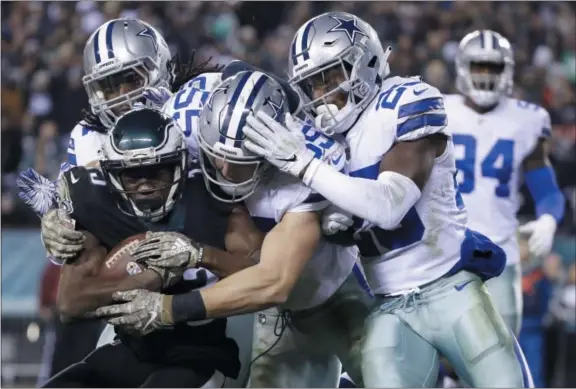  ?? MATT ROURKE — THE ASSOCIATED PRESS ?? Eagles wide receiver Nelson Agholor, bottom left, is tackled by Cowboys middle linebacker Jaylon Smith, top left, outside linebacker Leighton Vander Esch, center, and free safety Xavier Woods during the second half Sunday in Philadelph­ia.