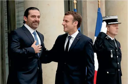  ?? PHOTO: REUTERS ?? French President Emmanuel Macron, right, and Saad al-Hariri react on the steps of the Elysee Palace in Paris, France.